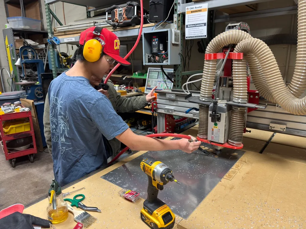 Student operating the CNC router in the fabrication shop